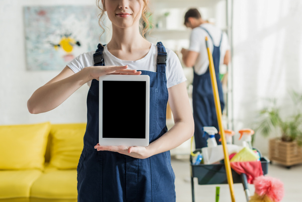 visão recortada do limpador sorridente segurando tablet digital com tela em branco
  - Foto, Imagem