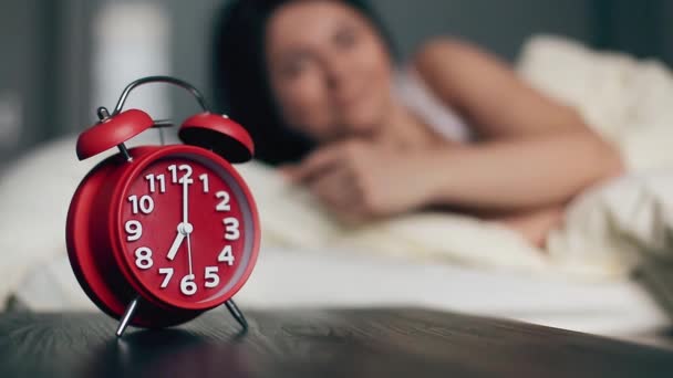 Woman turning off alarm clock lying in bed morning wake up happy smile  - Πλάνα, βίντεο