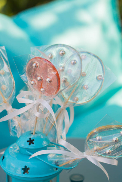 Lollypops en linterna turquesa en la mesa turquesa
 - Foto, Imagen