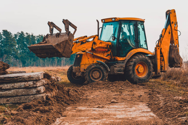 クローズアップ掘削機は、さらなる道路設置のためにバケツに土壌をロードします。2019 - 写真・画像