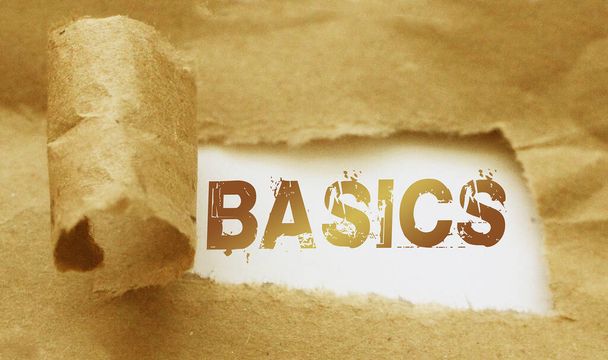 Das Wort Basics taucht hinter zerrissenem braunem Papier auf. Business Learning Konzept. - Foto, Bild