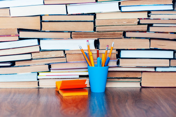 Pencils in holder, note paper and stack of books, school background for education learning concept - Photo, image