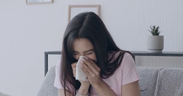 Kranke Millennial-Frau pustet sich zu Hause die Nase zu - Filmmaterial, Video