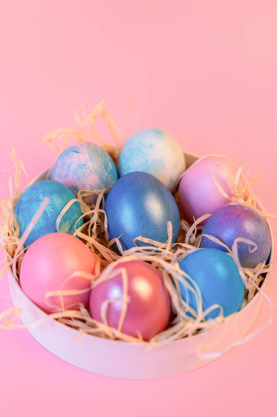  Nature morte avec des œufs décorés de Pâques dans une boîte sur un fond rose
. - Photo, image