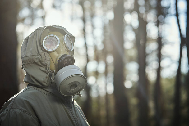 Ο άνθρωπος με μάσκα αερίου προστατεύει τον εαυτό του από τον κορωναϊό. - Φωτογραφία, εικόνα