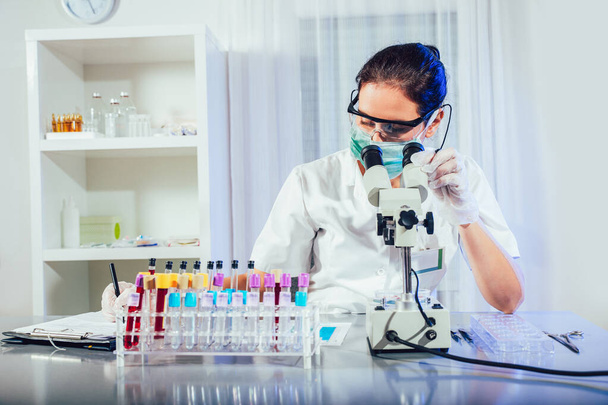 Technik laboratoryjny analizuje próbkę krwi w laboratorium. Koncepcja badań medycznych, farmaceutycznych i naukowych oraz rozwoju. - Zdjęcie, obraz