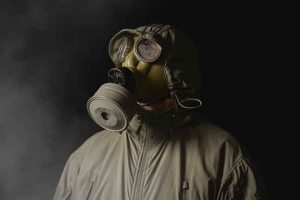 ガスマスクの男はコロナウイルスから身を守る - 写真・画像