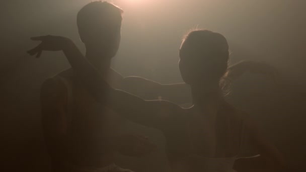 Sahne ışıkları altında dans eden profesyonel bale çifti büyük sahnede sigara içiyor. Sahne ışıkları altında güzel bir genç kadın ve erkek. Duygusal düet koreografik sanat icra ediyor. Ağır çekim. 4k - Video, Çekim
