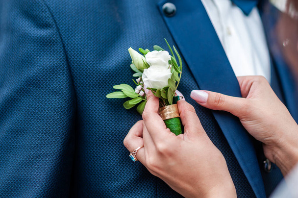 Woman wearing boutonniere on the groom - Photo, Image