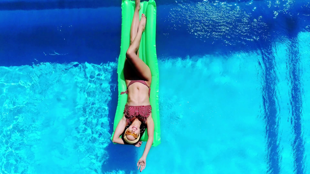 vrchol pohled na šťastnou dívku plavání na bazénu float v bazénu v létě - Záběry, video