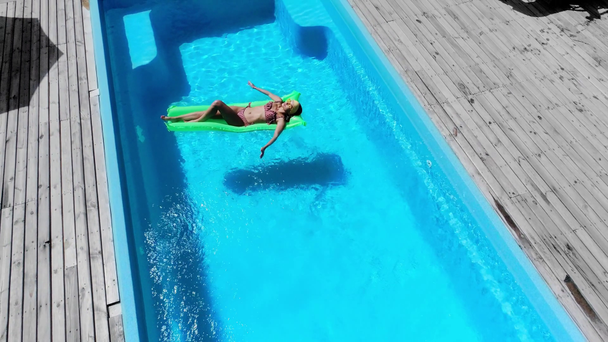 sexy dziewczyna odpoczywa na basen platforma w basen - Materiał filmowy, wideo