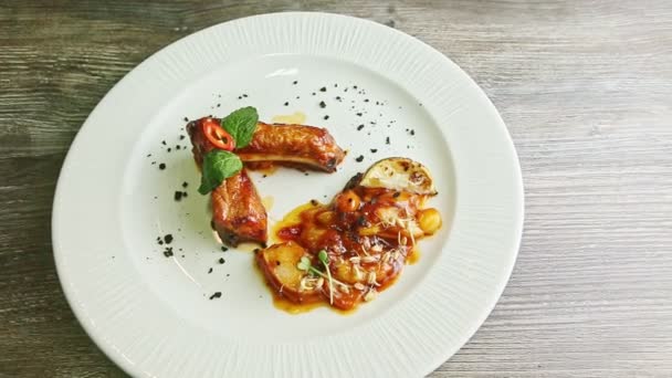 zoomare sulle costolette di carne grigliate decorate con salsa e guarnire sul piatto
 - Filmati, video
