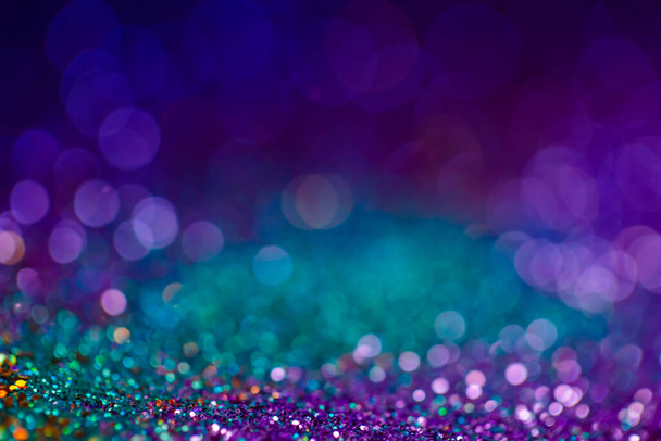 Festive bokeh glitters background, abstract shiny backdrop with circles,modern design overlay with sparkling glimmers. Blue, purple and green backdrop glittering sparks with glow effect. - Photo, image