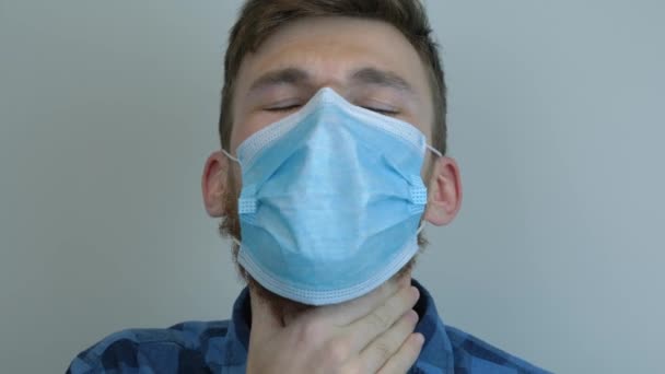Infected young man wearing medical face mask is coughing up blood. Tuberculosis epidemic. Pandemic protection of the Covid-19 coronavirus. Virus protection - Metraje, vídeo