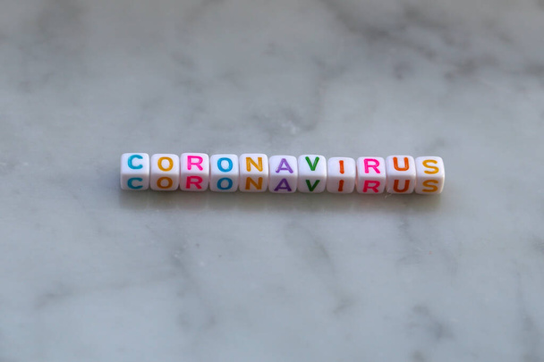 Coronavirus. Das Wort besteht aus kleinen Würfeln. - Foto, Bild
