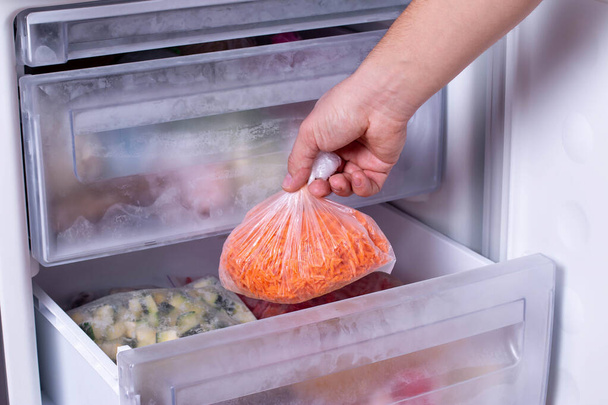 Bevroren wortel, diepgevroren groenten in zakken in de koelkast - Foto, afbeelding