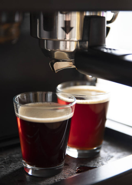 Primer plano de una máquina de café vertiendo café en tazas
 - Foto, imagen