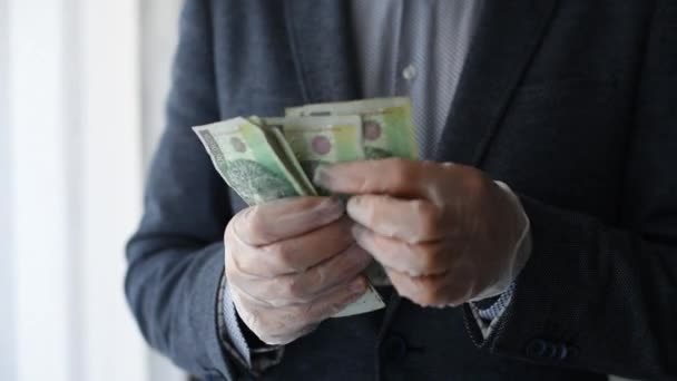 Man in suit counting Polish money zloty in protective gloves during coronavirus covid-19 epidemic. - Filmati, video