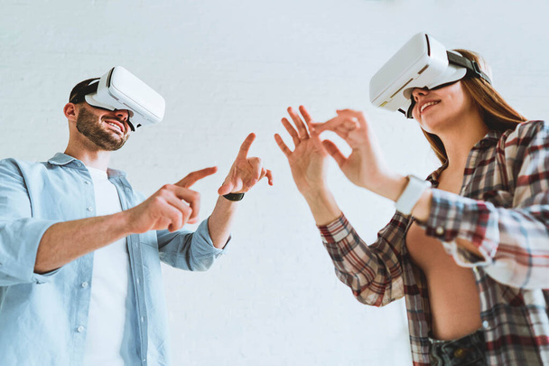 Young happy couple having fun with VR goggles headset glasses. - Foto, Bild