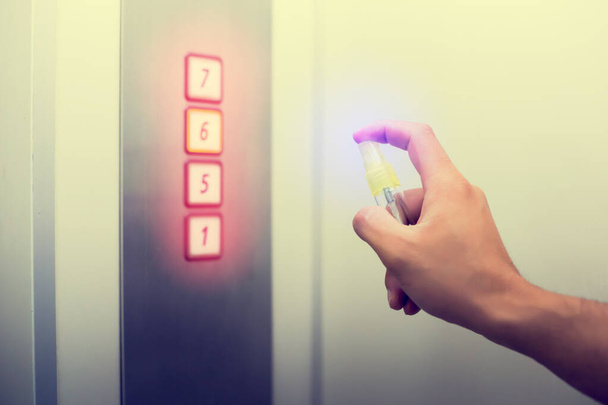 Cleaned staff Cleaned elevator switch button with alcohol spray in hospital or building office or condominium. Коронавирус (Covid-19) или бактерии, инфицированные защитой от прикосновения общественного объекта
. - Фото, изображение