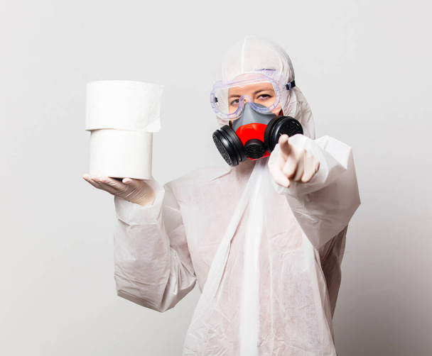 doctor in protection suit and glasses with mask holds toilet paper - Фото, зображення