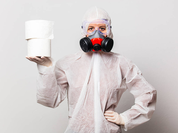 doctor in protection suit and glasses with mask holds toilet paper - Foto, Imagem