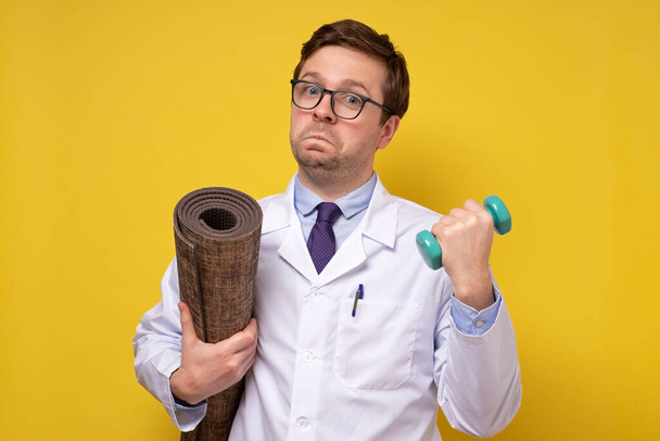 Mature man doctor holding dumbbells giving advice about healthy lifestyle. - Photo, Image