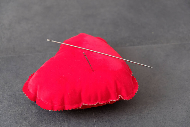 rode speldenkussen en een grote naainaald, naaldspreuk, - Foto, afbeelding