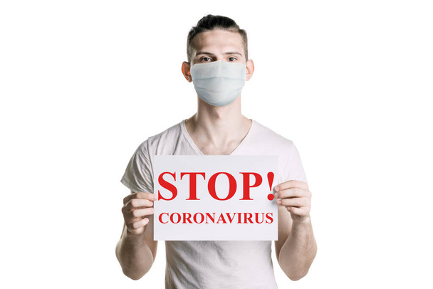若い男は碑文「ストップコロナウイルス」を保持しています。コロナウイルスの危険性。横枠 - 写真・画像