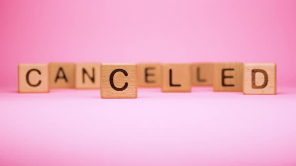 CANCELLED word made with building blocks, business concept. Word CANCELLED on pink background. Global mass gathering cancelled. Cancelled background, Plan changing. - Footage, Video