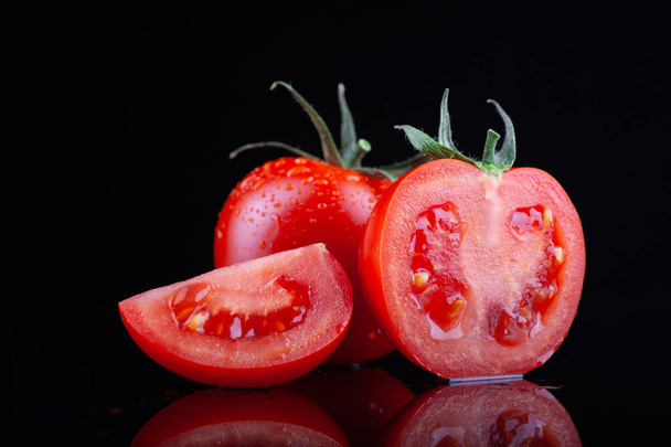  beautiful fresh tomatoes in beautiful droplets of water on a black background. copyspace - Фото, зображення