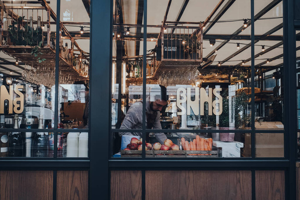 London UK - March 06, 2020: View through the window of staff cooking inside the restaurant in Covent Garden Market, one of the most popular tourist sites in London, UK. - Foto, afbeelding