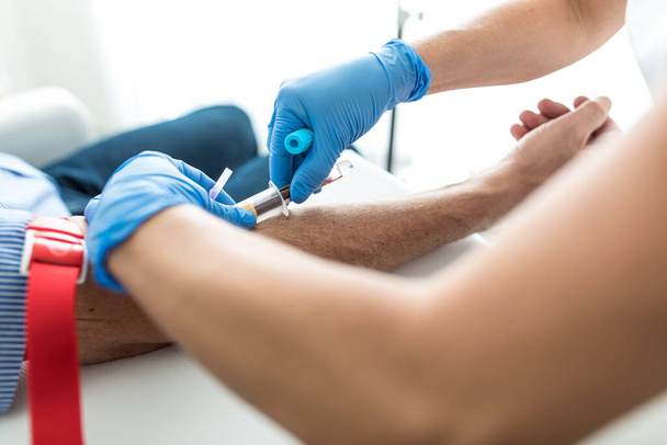Senior man having a blood test done by a nurse - Фото, изображение