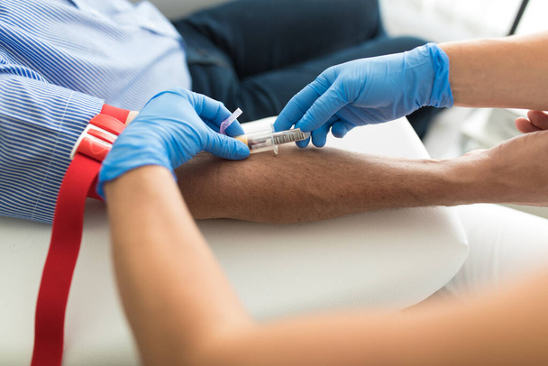 Senior man having a blood test done by a nurse - Фото, изображение