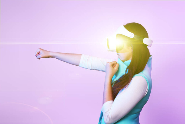 Nainen käyttää virtuaalitodellisuus kuulokkeet, pelaa peliä ja taistelevat
. - Valokuva, kuva