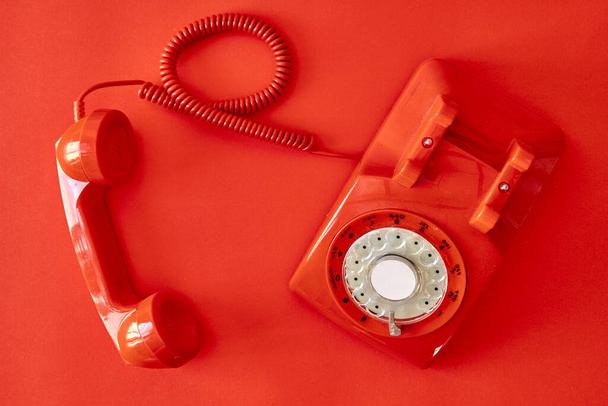 Uma foto de estúdio de um telefone rotativo vermelho
 - Foto, Imagem