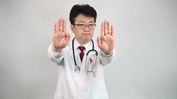 4К. Азиатский врач средних лет поднимает руку и выражает свое неодобрение.
. - Кадры, видео