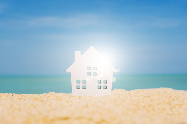 Μοντέλο ενός μικρού σπιτιού στην άμμο με φόντο τη φύση παραλία. Έννοια ζωής ονείρου. - Φωτογραφία, εικόνα