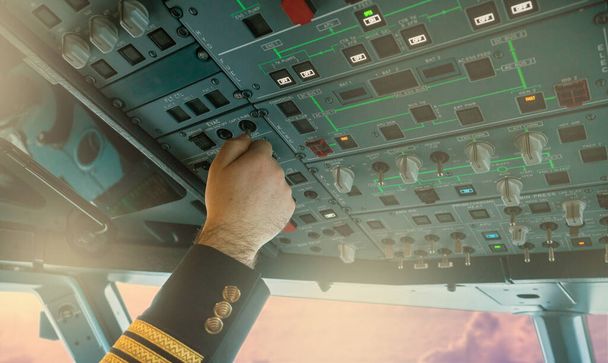 Πιλοτικό πάτημα κουμπιά στο εμπορικό αεροπλάνο πιλοτήριο - Φωτογραφία, εικόνα