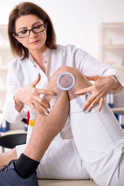 Kobieta lekarz sprawdzający u pacjentów elastyczność stawów z goniometrem - Zdjęcie, obraz