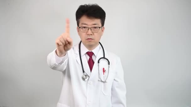 4K. Un médico asiático de mediana edad levanta la mano y expresa su desaprobación
 - Imágenes, Vídeo