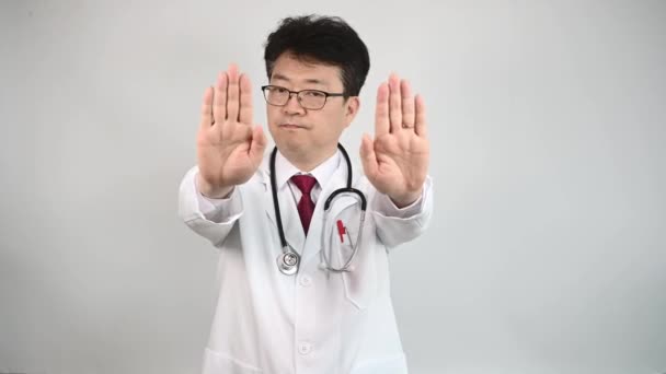 4K. Un médico asiático de mediana edad levanta la mano y expresa su desaprobación
 - Metraje, vídeo