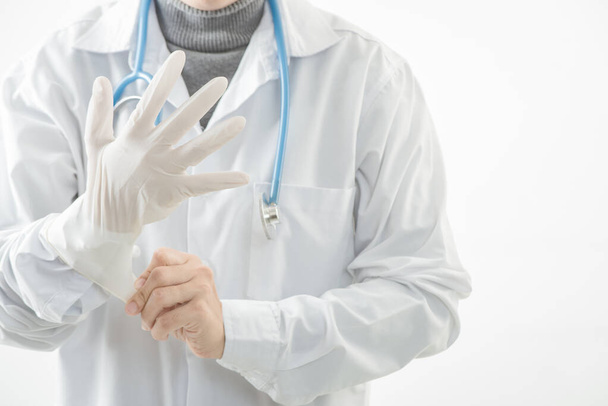 Close-up  doctor wearing gloves isolated on white background. Promoting people use face mask to protect themselves from virus infection in Corona virus crisis 2020. - Foto, Imagem
