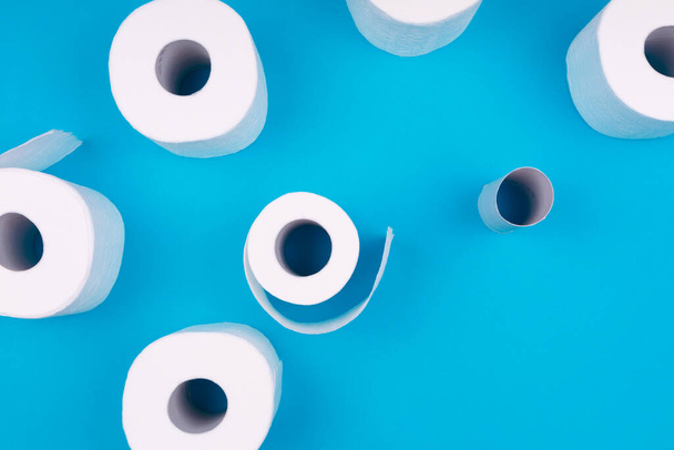 Toilettenpapierrollen auf dem hellblauen Hintergrund. Panikeinkaufskonzept für Coronavirus-Pandemie - Foto, Bild
