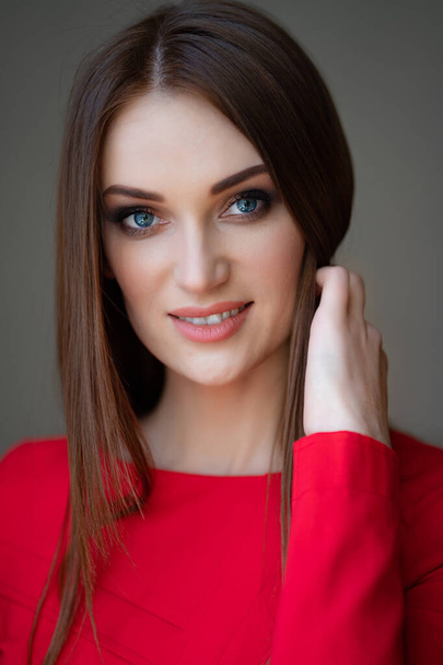 portrait beautiful girl in red corrects hair - Фото, изображение