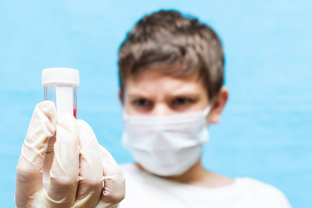 teenager holds a test tube with blood - Foto, Imagem