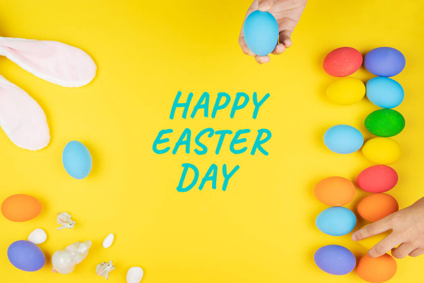 Giorno di Pasqua piccolo coniglietto orecchio con mano bambino e uova decorate
 - Foto, immagini