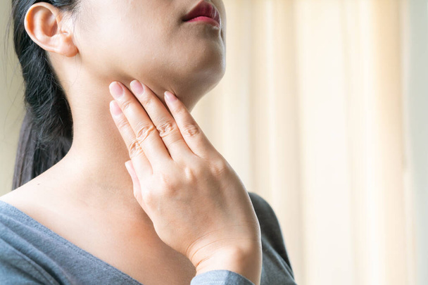 Sore Throat. Beautiful woman hand touching her pain neck. Woman healthcare concept - 写真・画像