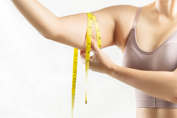 mujer gorda, mano de mujer pellizcando en su brazo gordo excesivo con cinta métrica, concepto de estilo de vida de dieta de mujer - Foto, Imagen