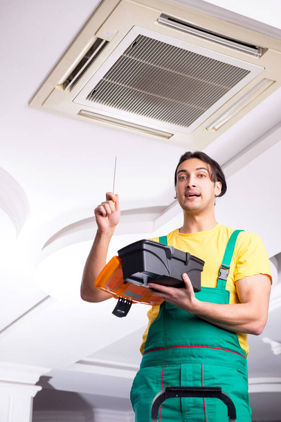 Young repairman repairing ceiling air conditioning unit - Photo, Image